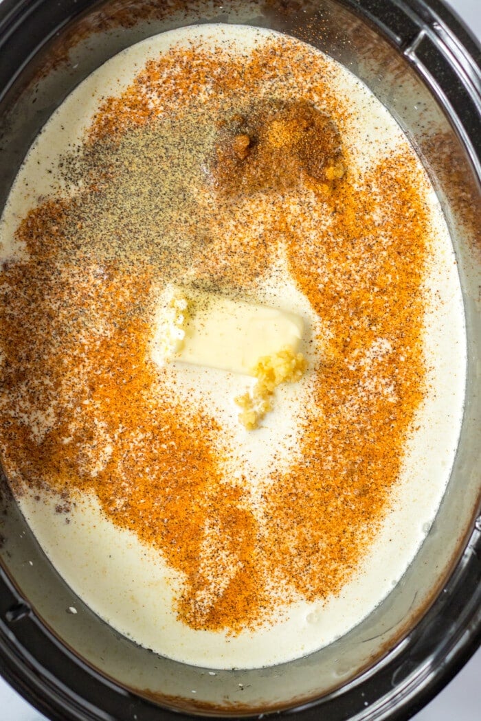 butter and spices with cream in slow cooker
